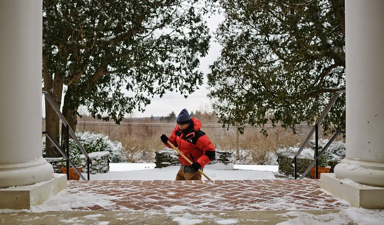 Facility worker shoveling snow